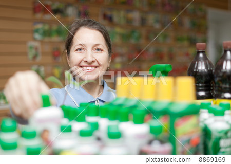 female gardener chooses fertilizer 8869169