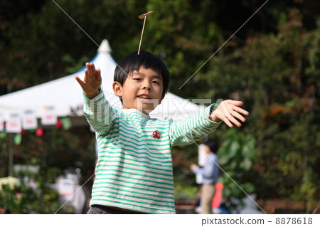 A boy flying a bamboo dragonfly 8878618