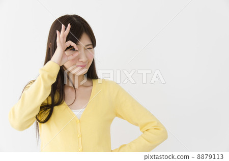 Young woman looking into an OK sign 8879113