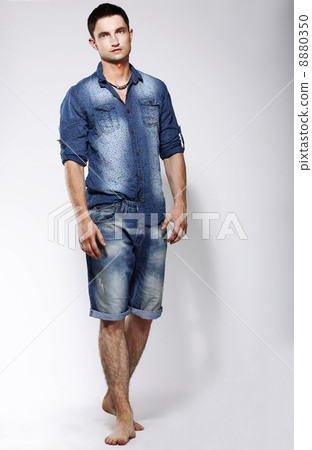 Full Length Portrait of Young Confident Barefoot Man in Blue Jeans 8880350