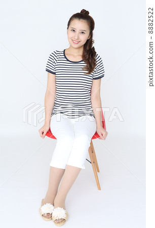 A young woman sitting on a chair 8882522