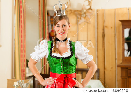 Young woman as queen in Traditional Bavarian Tracht in restaurant Young woman as queen in Traditional Bavarian Tracht in restaurant 8890230