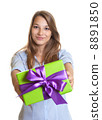 Smiling young woman showing a christmas gift 8891850