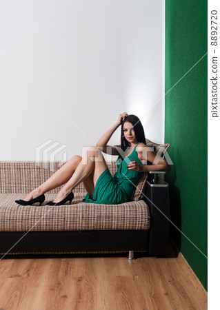 brunette sitting on sofa brunette sitting on sofa 8892720