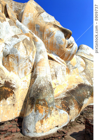 giant reclining buddha face statue over blue sky 8909737