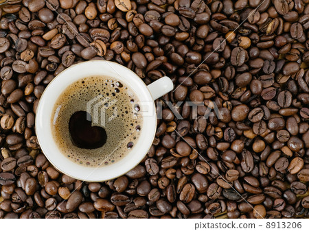 Background from coffee grains and a cup from coffee, the top vie 8913206