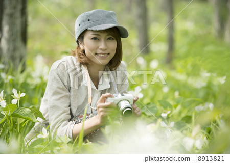 拿著mirrorless單鏡頭照相機和微笑的婦女 8913821