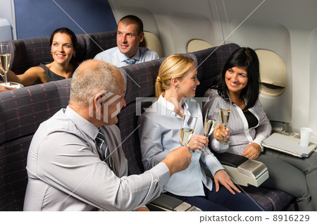Airplane cabin businesspeople toasting champagne 8916229