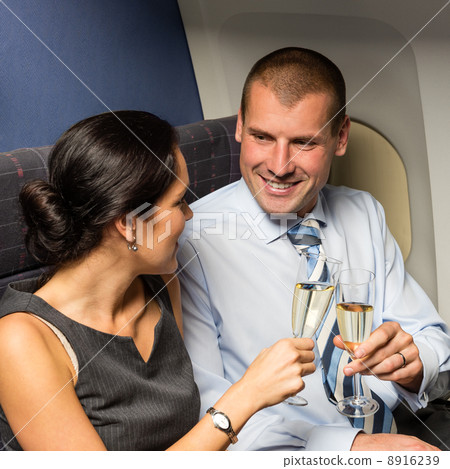 Flight cabin business partners toasting champagne 8916239