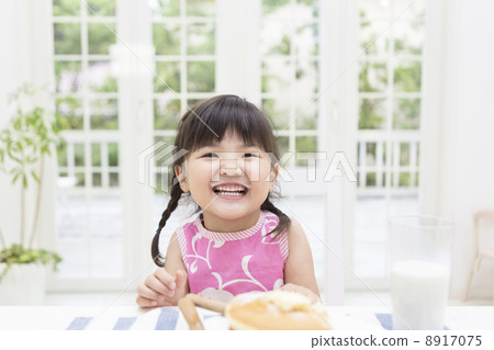 Smiling girl sitting at the table 8917075