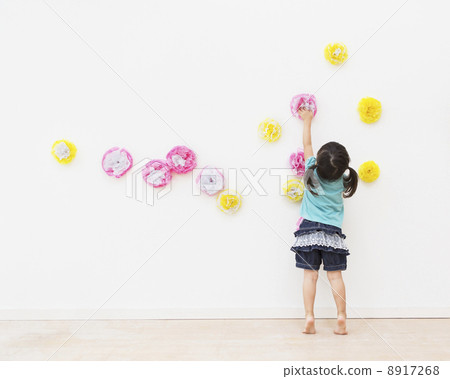 Girl decorating flower decoration on wall 8917268