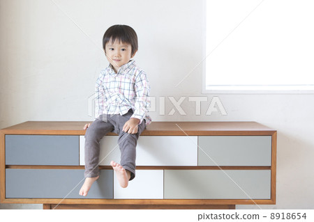 一個男孩坐在桌子上 8918654