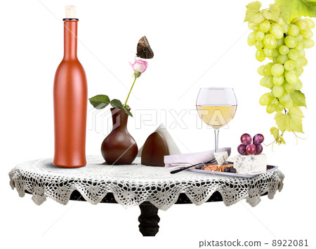 bottle, wine glass with flower and food on a table 8922081