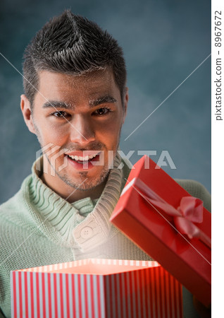 Excited man opening big gift box Excited man opening big gift box 8967672