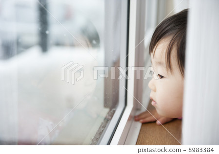 A child looking out the window 8983384