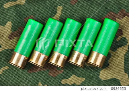 Old hunting cartridges on camouflage background 8986653