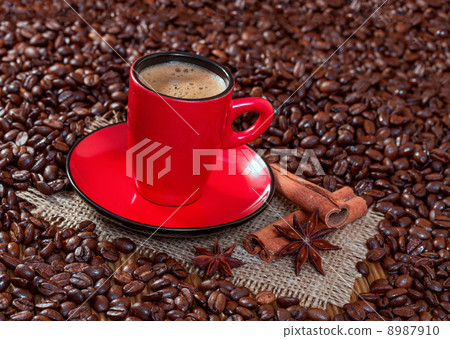Coffee in a red cup with cinnamon and anise stars. Coffee in a red cup with cinnamon and anise stars. 8987910