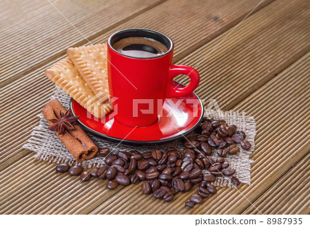 Coffee in a red cup with cinnamon and anise stars. 8987935