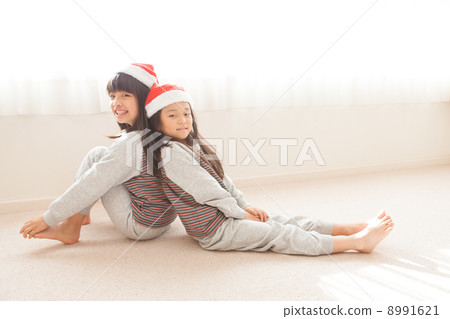 Sisters wearing Santa's hat Sisters wearing Santa's hat 8991621