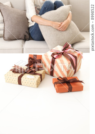 A girl sitting on a gift and a sofa 8998522