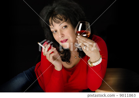 Mature woman looking at brandy closely Mature woman looking at brandy closely 9011863