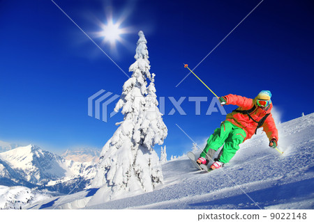 Skier skiing downhill in high mountains 9022148