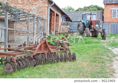 Antique tractor and plow on the farm. 9022969