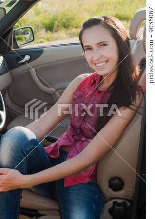 Smiling brunette woman in car 9035067