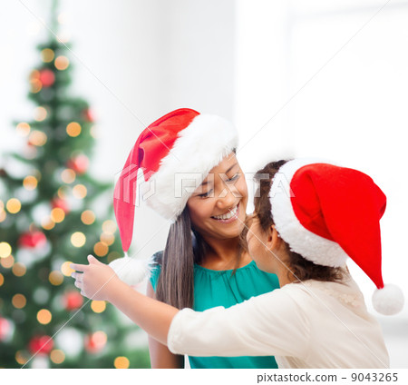 hugging mother and daughter in santa helper hats hugging mother and daughter in santa helper hats 9043265