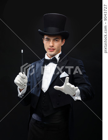 magician in top hat with magic wand showing trick 9043727