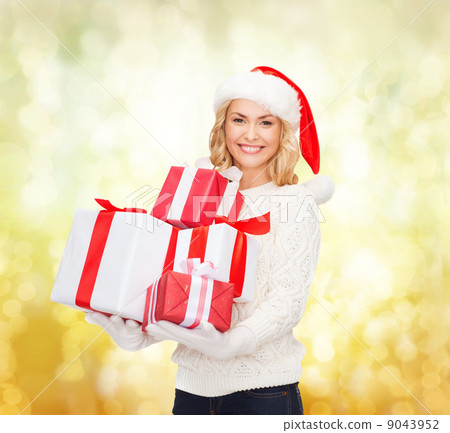 woman in santa helper hat with many gift boxes woman in santa helper hat with many gift boxes 9043952
