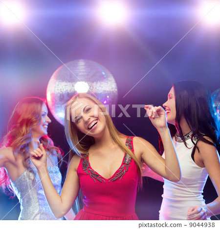 three smiling women dancing in the club 9044938