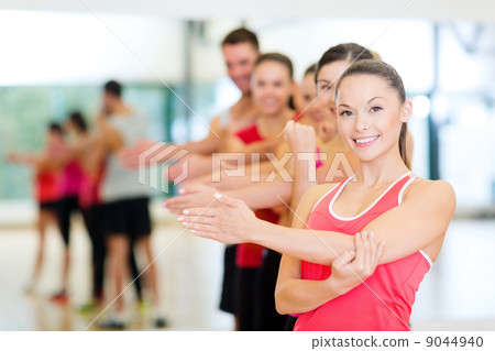 group of smiling people stretching in the gym group of smiling people stretching in the gym 9044940
