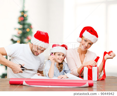 smiling family in santa helper hats with gift box smiling family in santa helper hats with gift box 9044942