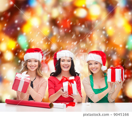 smiling women in santa helper hats with gift boxes smiling women in santa helper hats with gift boxes 9045166