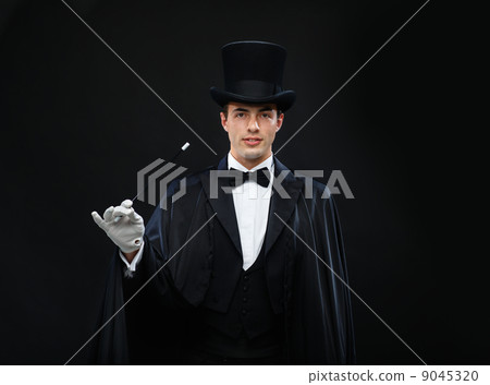 magician in top hat with magic wand showing trick 9045320