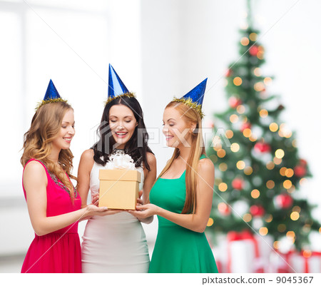 three smiling women in blue hats with gift box 9045367