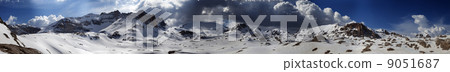 Panorama of snowy winter mountains with blue sky and dark clouds Panorama of snowy winter mountains with blue sky and dark clouds 9051687