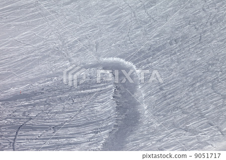 Off-piste slope and snowy road with trace from ski and snowboard 9051717