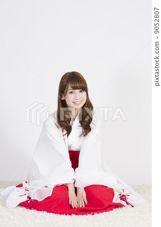 A young lady in a shrine maiden figure 9052807