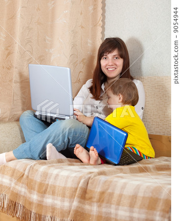 Happy woman with toddler using laptops Happy woman with toddler using laptops 9054944
