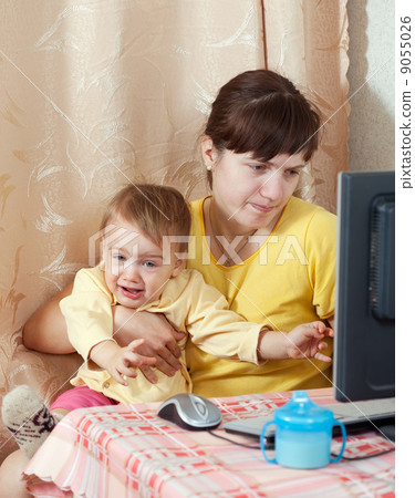Woman with crying baby working  with computer 9055026