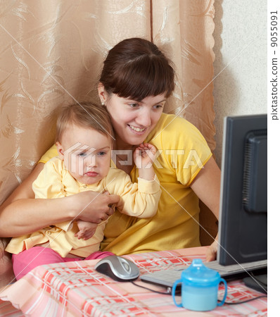 Woman with  baby working  with computer 9055091