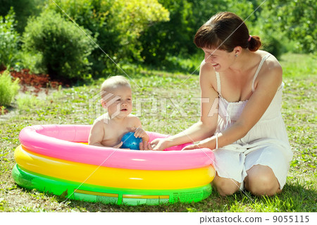 baby swimming  in  inflatable pool 9055115
