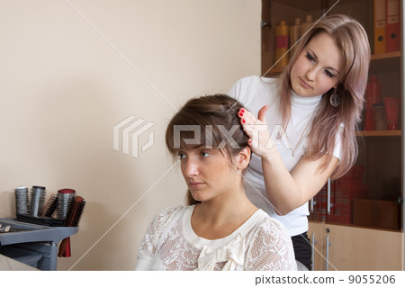 hairdresser works on woman hair 9055206