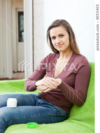 Beautiful woman puts cream on hands Beautiful woman puts cream on hands 9055403
