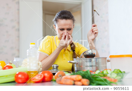 woman holding her nose because of bad smell from soup 9055611