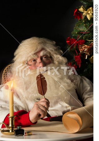 Santa Claus sitting at home and writing a letter 9068920