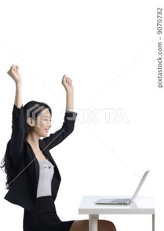 Young business woman using laptop celebrating side view studio white background  9070782