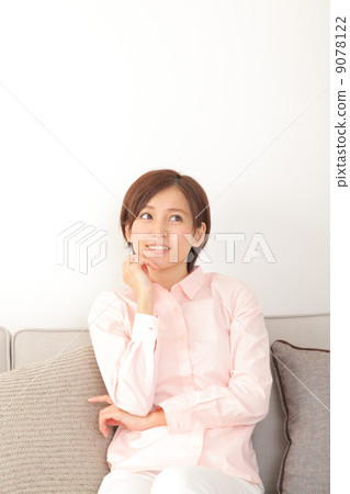 A woman who sits on a sofa and thinks 9078122
